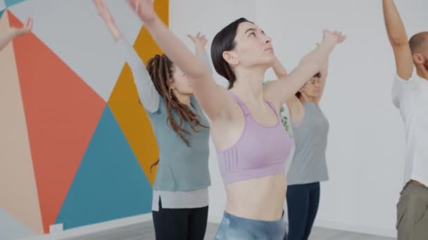 Grupo de estudiantes concentrados en equilibrar asanas de yoga en el club de salud — Vídeos de Stock