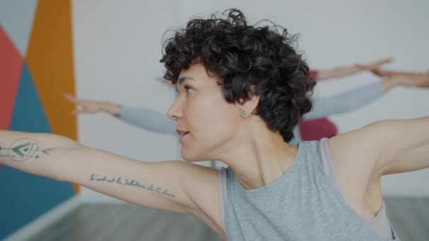 Insegnante di yoga che dimostra asana parlare durante la lezione di gruppo in studio — Video Stock