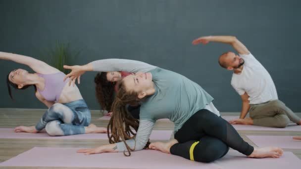 Gençlik yoga yapıyor İnek Yüzlü Poz sonra elleri namaste ile minderlerin üzerinde gevşiyor — Stok video