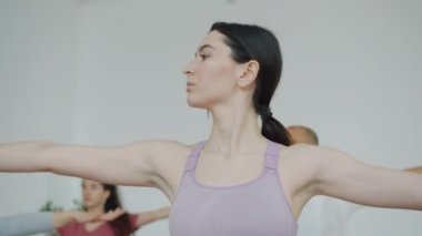 Spor merkezinde yoga yaparken vücudunu hareket ettiren çekici bir kadın.