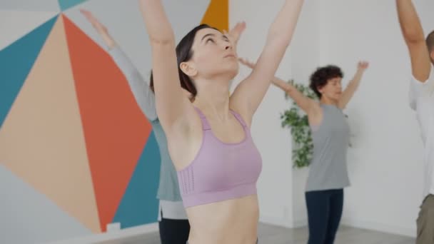 Gezonde jonge mensen yoga studenten gericht op het balanceren van asanas binnen in de studio — Stockvideo