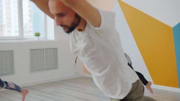 Étudiants de yoga hommes et femmes concentrés sur l'équilibrage asanas dans un studio confortable — Video