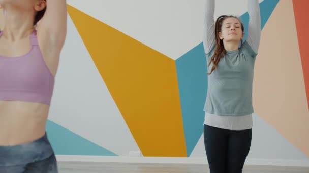 Σύγχρονη άσκηση νεολαίας στο yoga club φορώντας μοντέρνα ρούχα απολαμβάνοντας τον αθλητισμό — Αρχείο Βίντεο