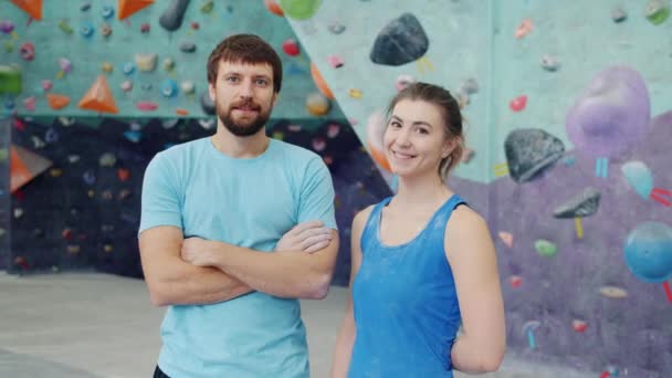 Retrato de hermosa pareja hombre y mujer de pie en el centro de escalada mirando a la cámara — Vídeos de Stock