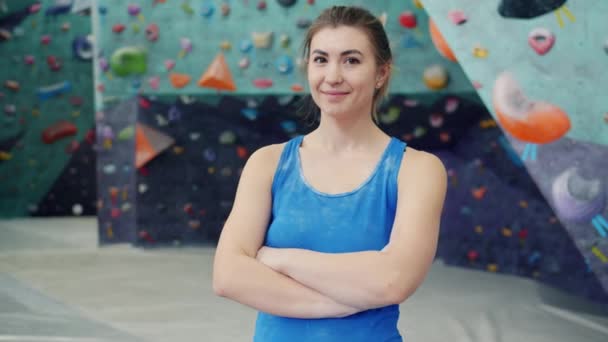 Porträt einer attraktiven jungen Frau, die allein im Kletterzentrum steht und lächelt — Stockvideo