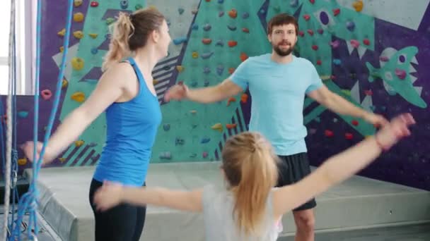 Повільний рух щасливої сім'ї жінки, чоловіка і маленької дівчинки, що займається скелелазінням спортзалу — стокове відео