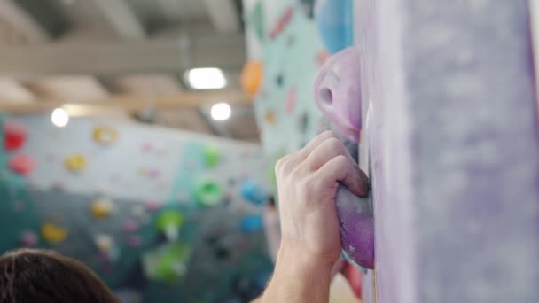 Spor salonunun duvarına tırmanan yetenekli erkek tırmanışçıların yavaş çekimde tek başına antrenman yapmaları. — Stok video