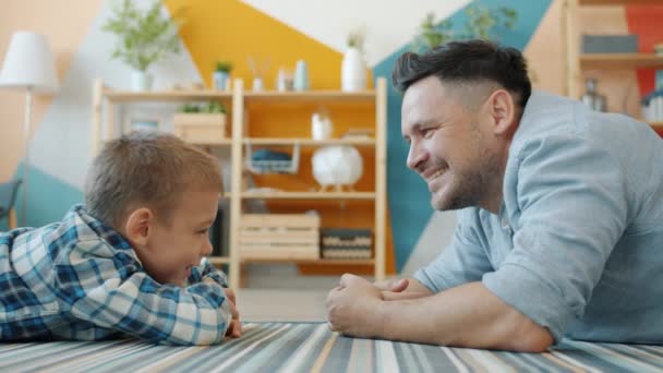 Cámara lenta del hombre y el niño hablando compartiendo ideas divirtiéndose en apartamento moderno — Vídeos de Stock