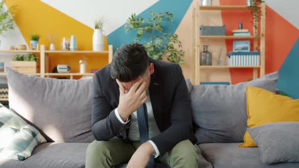 Gestresste zakenman met ernstige hoofdpijn die het hoofd thuis raakt — Stockvideo