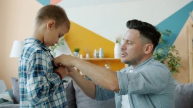 Sevgi dolu bir baba çocuğa kıyafet konusunda yardım ediyor sonra da evde sevgisini ifade ediyor.