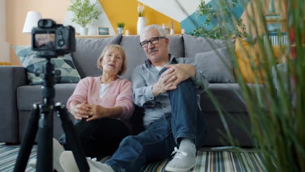 Senior man och kvinna vloggare inspelning video visar tummen upp med kameran hemma — Stockvideo