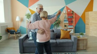 Evde dans eden yaşlı çiftin romantik müziklerin keyfini çıkarması.