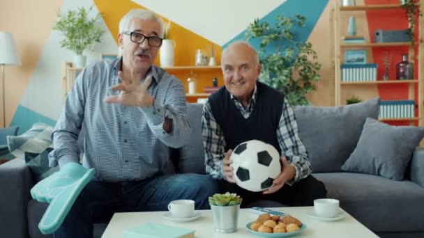 Portret van vrolijke voetbalfans oudere mannen kijken naar wedstrijd op tv juichen thuis — Stockvideo