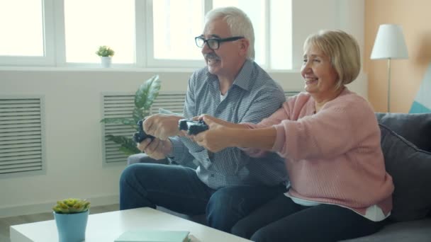 Glückliches Paar alte Dame und Mann unterhaltsam mit Videospiel tun High-Five im Haus — Stockvideo