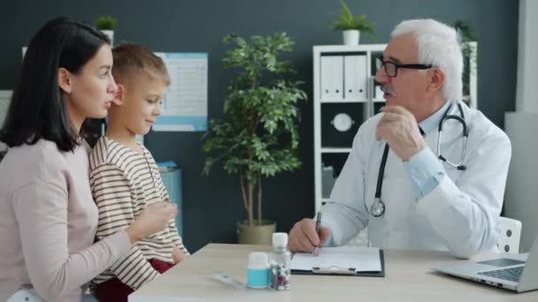 Mãe e filho conversando com o médico durante consulta no hospital infantil — Vídeo de Stock