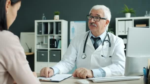 Médico masculino e paciente do sexo feminino conversando apertando as mãos durante a consulta no hospital — Vídeo de Stock