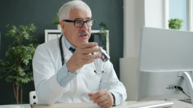 Klinikteki hastayla çevrimiçi istişare sırasında tıbbi uzman tedaviyi tartışıyor