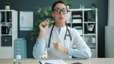 Hastanede ilaç öneren neşeli genç bayan doktorun portresi.