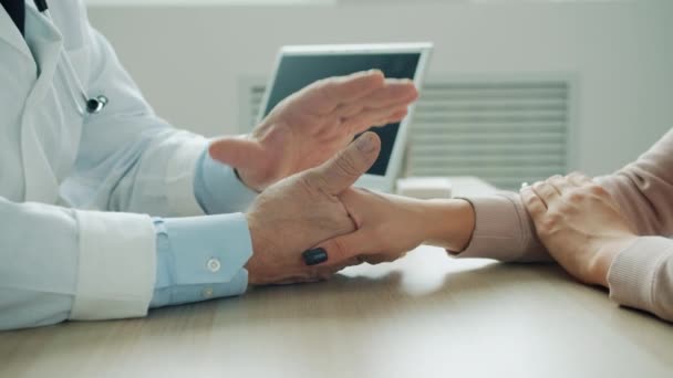 Manlig läkare som håller kvinnliga patienter hand stödjande kvinna på sjukhus kontor — Stockvideo