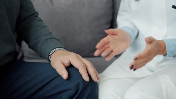 Primer plano de la doctora sosteniendo a los ancianos hablando con la mano expresando el cuidado en casa — Vídeo de stock