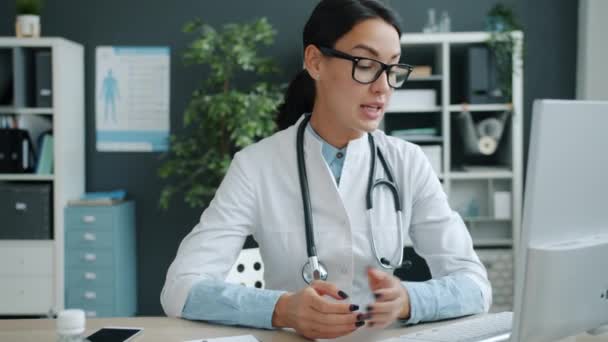 Professionele arts geeft online overleg vanuit het ziekenhuiskantoor via laptop — Stockvideo