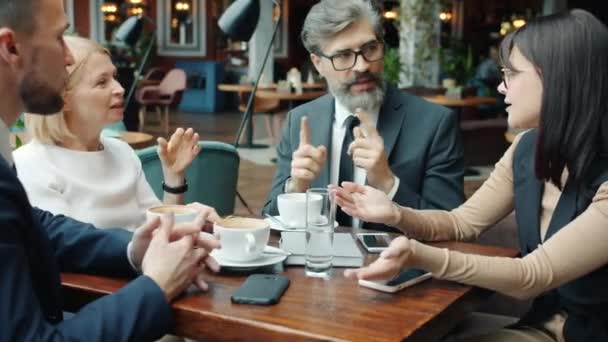 Группа предпринимателей Мужчины и женщины обсуждают бизнес в кафе — стоковое видео