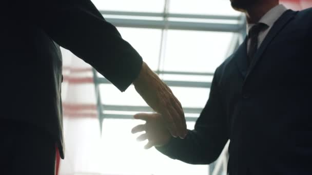 Close-up slow motion van mannen in pakken schudden handen in office center foyer — Stockvideo