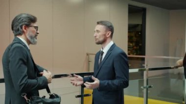 İş adamlarının, ofis lobisinde konuşan kadın ve erkeklerin yavaş hareketleri.