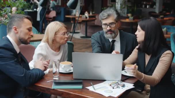 Zakenmensen en zakenvrouwen praten tijdens gesprekken in restaurant met behulp van computer — Stockvideo