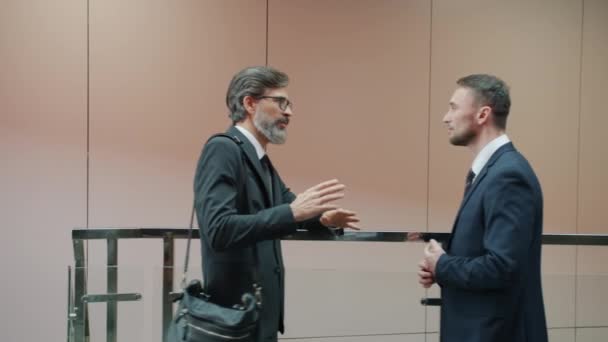 Trabalhadoras de escritório masculinas e femininas conversando no lobby do centro de negócios em grupos — Vídeo de Stock