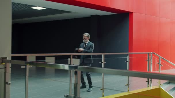Zeitlupe: Reifer Geschäftsmann tanzt in Büro-Lobby und feiert gute Nachrichten — Stockvideo