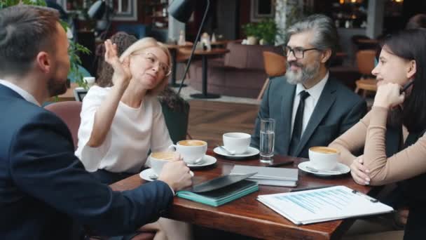 Счастливые коллеги дают пять и смеются во время обеденного перерыва в кафе — стоковое видео