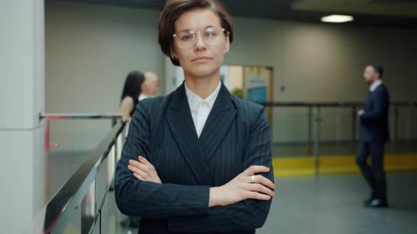 Portrait au ralenti d'une jeune femme d'affaires ambitieuse debout dans le hall du bureau avec un visage sérieux — Video