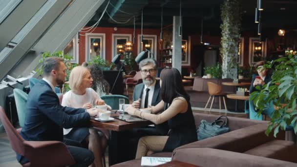 Radosni koledzy dojrzewają i młodzi mężczyźni i kobiety rozmawiają w kawiarni podczas przerwy obiadowej — Wideo stockowe