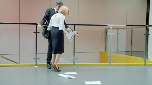 Homme d'affaires mature se heurtant à une femme dans le hall du bureau s'excusant en serrant la main — Video