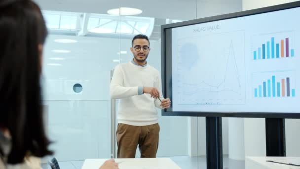 Hombre de negocios árabe dando presentación sobre las ventas utilizando pizarra digital en la oficina — Vídeo de stock
