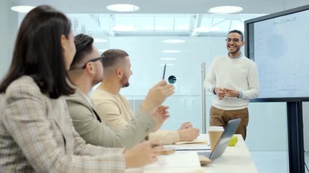 Allegro uomo mediorientale che parla con un gruppo di persone in sala conferenze utilizzando lo schermo digitale — Video Stock