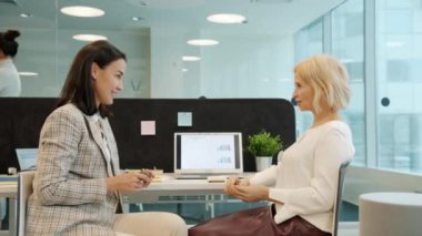 Mesut iş kadını meslektaşlar açık uzay ofisinde sohbet ediyorlar.