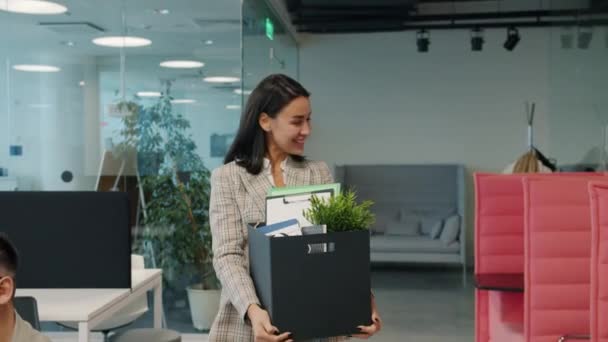 Slow motion av glada affärskvinna lämnar jobbet med låda med tillhörigheter ler sluta — Stockvideo