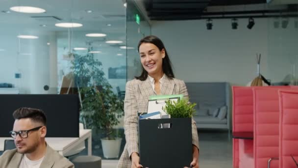 Šťastná mladá dáma bývalý zaměstnanec odchází z práce opustit kancelář s krabicí věcí — Stock video