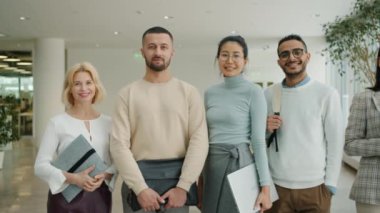 Ofis koridorunda gülümseyen mutlu iş adamlarının portresi.