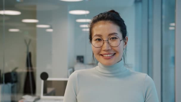 Retrato de atractiva empresaria asiática con gafas sonrientes en la oficina — Vídeo de stock