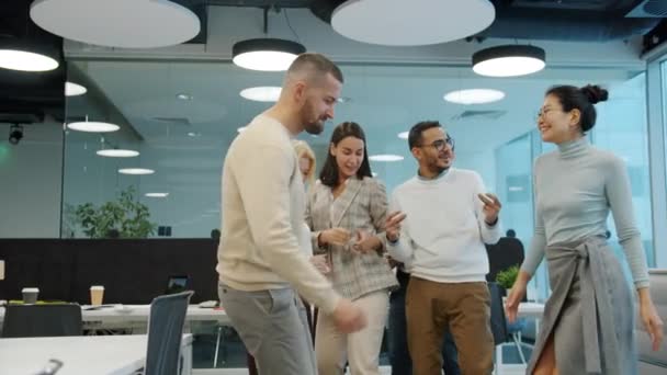Uluslararası şirketin neşeli çalışanları açık uzay ofisindeki şirket partisinde dans ediyorlar. — Stok video