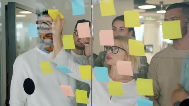 Team creativo di colleghi che utilizzano appunti adesivi per la pianificazione del lavoro di risoluzione dei problemi in ufficio — Video Stock