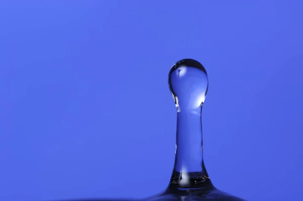Wasserspritzer auf blauem Hintergrund mit Kopierraum — Stockfoto
