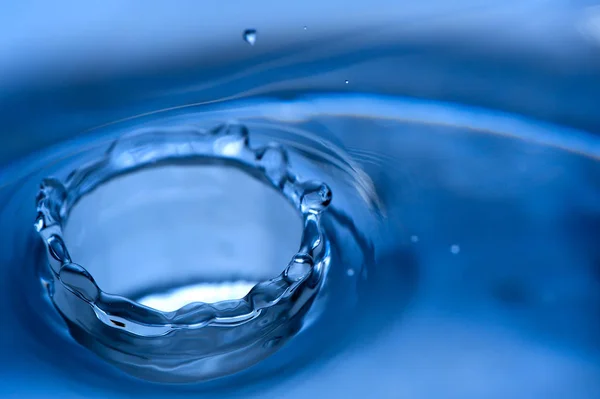 Vatten stänk på blå bakgrund — Stockfoto