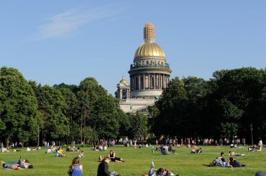 Saint Petersburg, Russia - June 25, 2016: People relaxing on the lawn next to St. Isaac Cathedral