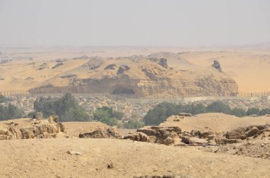 Gri bulutlar altında kum toz içinde piramit