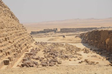 Gri bulutlar altında kum toz içinde piramit