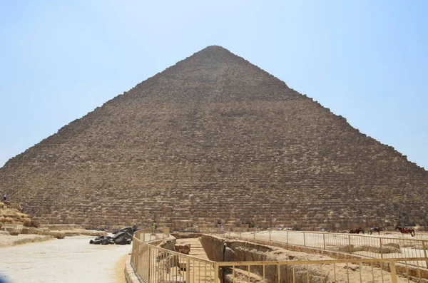 Pyramid in sand dust under gray clouds — Stock Photo, Image